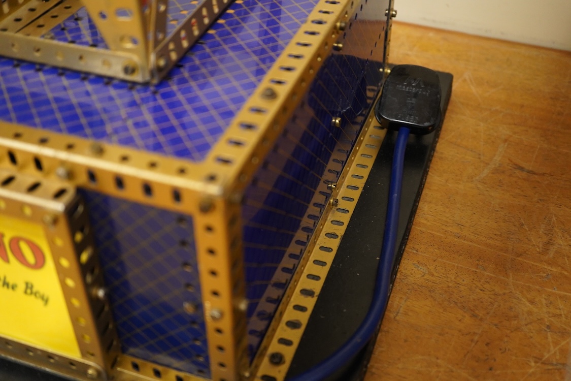 A Meccano model of a fairground ride, incorporating an electric motor in the base and lighting throughout, built in the style of a shop display centrepiece, approx 106cm high, 85cm diameter